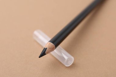 Bej arka planda siyah kaş kalemi, yakın plan.