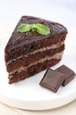 Nefis bir parça pasta, nane ve çikolata ışık masasında, yakın plan.