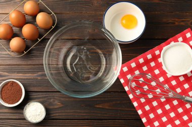 Krem şanti yapıyorum. Kase, çırpı ve malzemeler ahşap masada, düz yatıyordu.