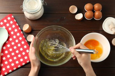 Ahşap masada yumurta beyazı çırpan bir kadın.
