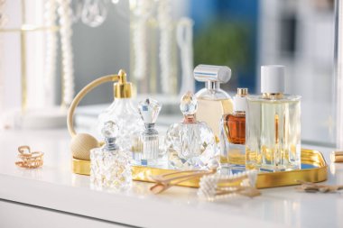 Beyaz masadaki farklı parfümlerden şişeler, yakın plan.