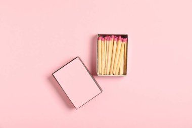 Kibrit ve kutu pembe arka planda, düz yerde. Tasarım için model