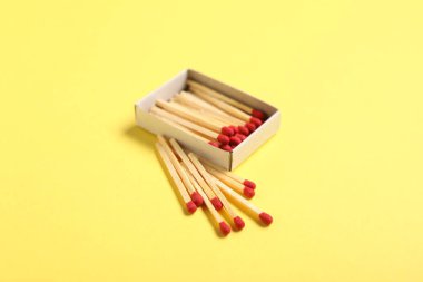 Sarı arkaplanda kibrit ve açık kutu