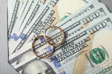 İki altın alyans, bir dolarlık banknotlar ve zarf.