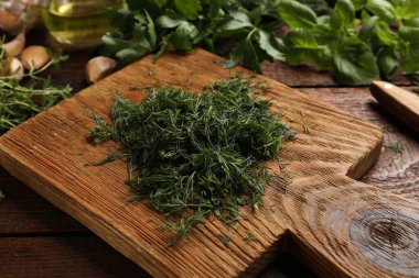 Farklı taze otlar ve baharatlar ahşap masada, yakın plan.