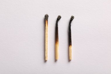 Açık gri arkaplanda yanmış kibritler, düz yatış