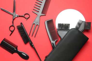 Kırmızı arka planda farklı kuaför aletleri, düz yatıyordu