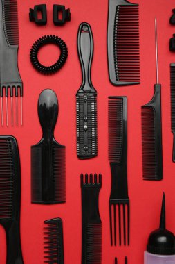 Kırmızı arka planda farklı kuaför aletleri, düz yatıyordu