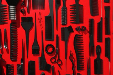 Kırmızı arka planda farklı kuaför aletleri, düz yatıyordu