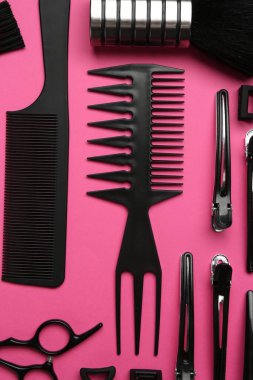 Pembe arka planda farklı kuaför aletleri, düz yatış