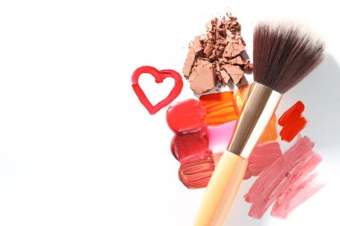 Beyaz arka planda farklı kozmetik ürünleri ve makyaj fırçası var. Metin için boşluk