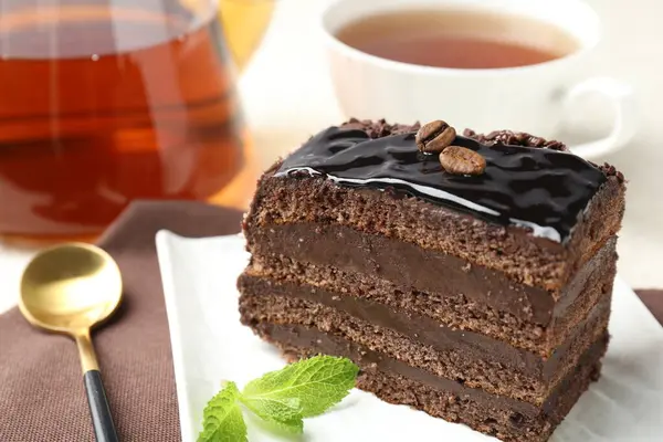 Nane, kaşık ve çayla servis edilen çikolatalı kek.