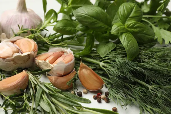 Beyaz masada farklı taze otlar ve baharatlar, yakın plan.