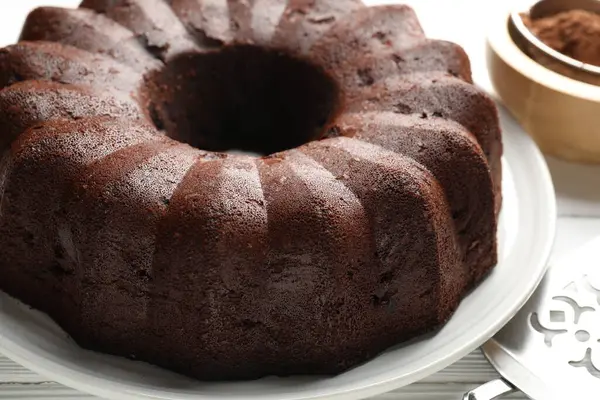 Lezzetli çikolatalı kek, kakao tozu ve servis masası, yakın plan.