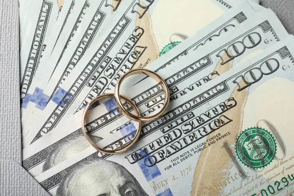 İki altın alyans, bir dolarlık banknotlar ve zarf.