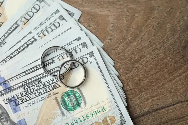 Gümüş alyanslar ve bir dolarlık banknotlar. Metin için boşluk