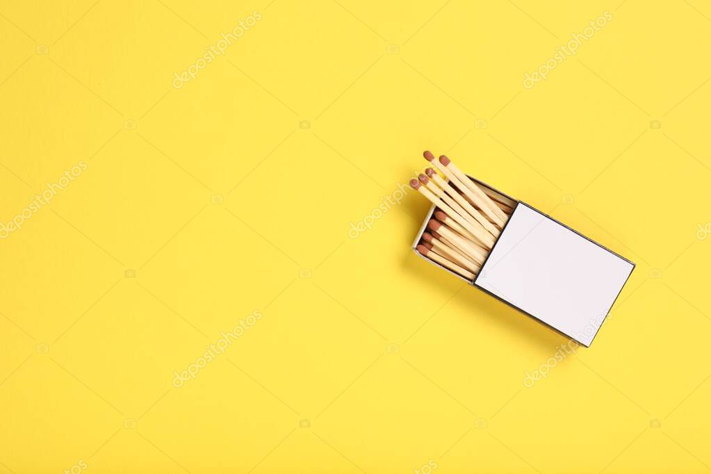 Matches in box on yellow background, top view. Mockup for design