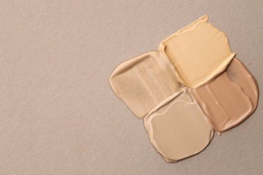 Gri arka planda, düz zeminde renkli cilt temelleri. Metin için boşluk