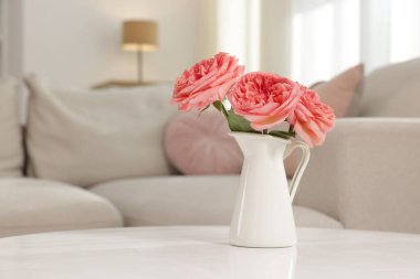 Beyaz masadaki güzel çiçekli vazo kapalı, yakın plan.