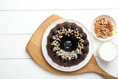 Fındıklı çikolatalı kek ve beyaz ahşap masada bir bardak süt.