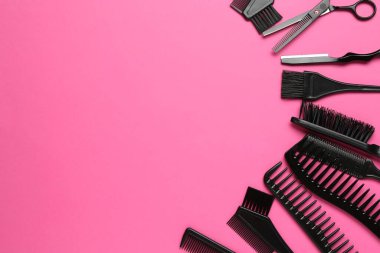 Pembe arka planda farklı kuaför aletleri, düz yatış. Metin için boşluk