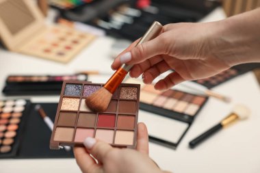 Makyaj masasında fırça ve göz falı olan kadın, yakın plan.