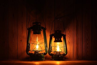 Ahşap masada iki eski gaz lambası.