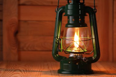 Ahşap masada eski tip gazyağı lambası, yakın plan. Metin için boşluk