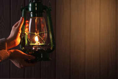 Ahşap arka planda klasik gaz lambası olan adam, yakın plan. Metin için boşluk