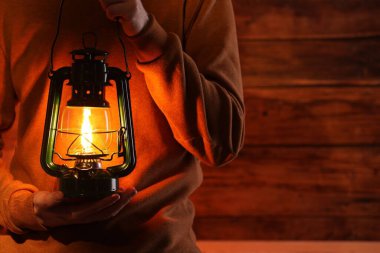 Ahşap arka planda klasik gaz lambası olan adam, yakın plan. Metin için boşluk