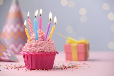 Kekin içinde mum yakmak, fıskiyeler ve bulanık ışıklara karşı masanın üstünde parti dekorasyonu. Metin için boşluk