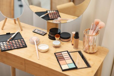 Farklı makyaj ürünleri ve kapalı mekandaki gösteriş fırçaları, yakın çekim