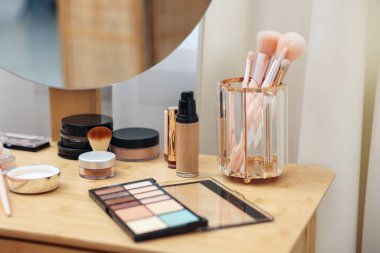 Farklı makyaj ürünleri ve kapalı mekandaki gösteriş fırçaları, yakın çekim