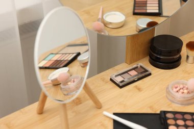 Farklı makyaj ürünleri ve kapalı mekanlarda makyaj aynası, yakın çekim.
