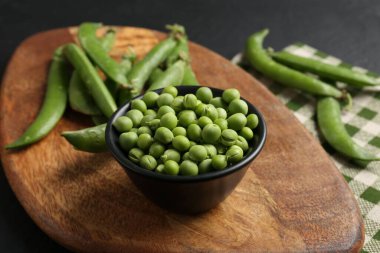 Taze taze bezelyeler siyah masada, yakın plan.