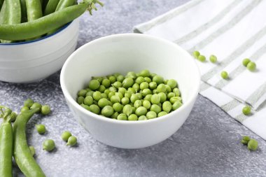 Gri masada taze taze taze bezelyeler, yakın plan.