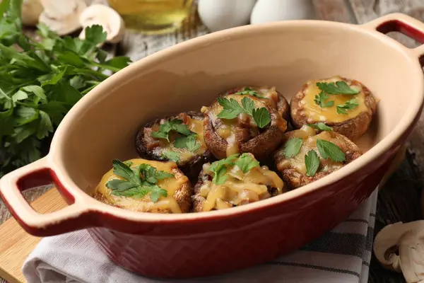 Eritilmiş peynirli ve maydanozlu lezzetli mantarlar. Yemek masasında, yakın plan.