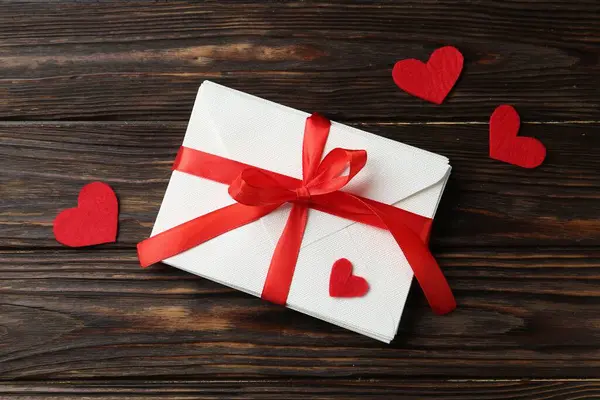 Aşk mektupları ve kırmızı kalpler ahşap masada, düz yatıyordu.