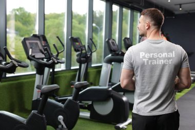 Spor salonunda üzerinde yazı olan tişört giyen spor ayakkabıları. Arka plan