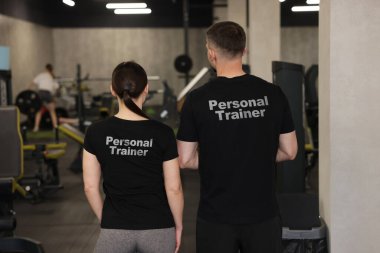 Spor salonunda üzerinde yazılar olan tişörtler giyen spor ayakkabıları. Arka plan