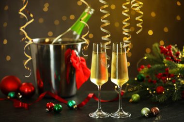 Köpüklü şarap, altın yılanbalığı şeritleri ve karanlık arka planda bulanık ışıklara karşı şenlikli dekor.