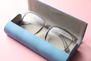 Pembe arka planda şık gözlüklü çanta, yakın plan.