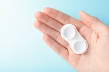 Açık mavi arka planda kontak lensli kadın, yakın plan. Metin için boşluk