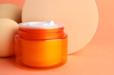Turuncu arka plandaki kavanozda nemlendirici vücut kremi sunumu, yakın plan. Metin için boşluk