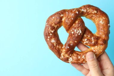 Açık mavi arka planda lezzetli krakerli kadın, yakın plan. Metin için boşluk