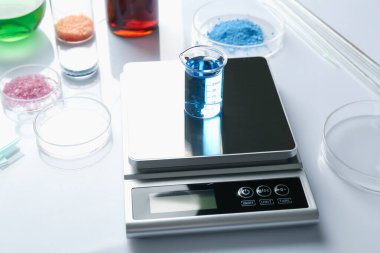 Beyaz arka planda, örnek kabı ve diğer laboratuvar ekipmanlarıyla ölçeklendir, kapat