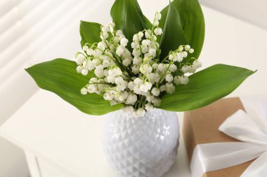 Vadi çiçeklerinin güzel zambakları ve kapalı bir masada hediye, yakın plan.