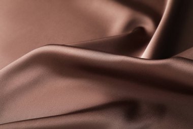 Arkaplan olarak buruşuk açık kahverengi ipek kumaş, yakın plan