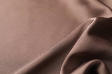 Arkaplan olarak buruşuk açık kahverengi ipek kumaş, yakın plan