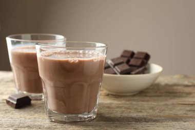 Bardakta çikolatalı süt ve ahşap masada parçalar, yakın plan. Metin için boşluk